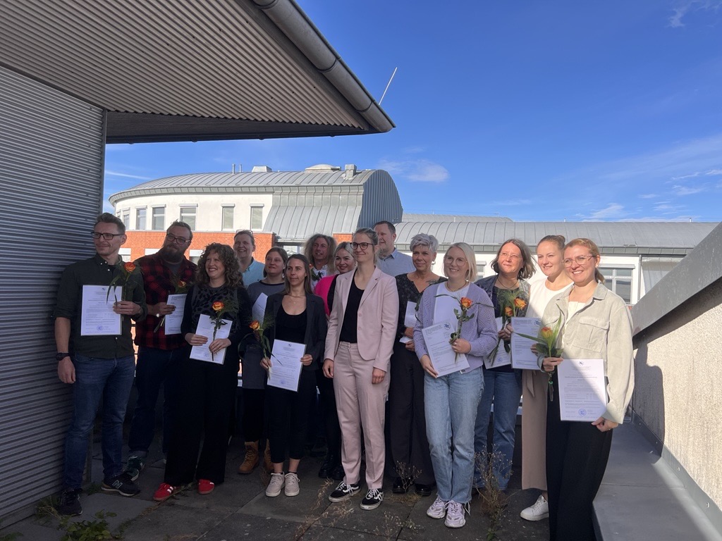 Gruppe von Menschen mit Zeugnissen in der Hand